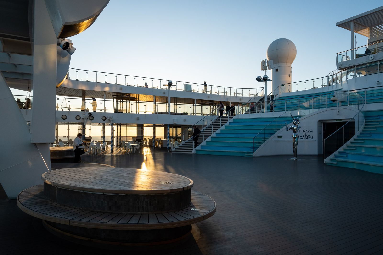 The open top deck of a cruise ship at sunset, the kind of space cruise ship reviews describe