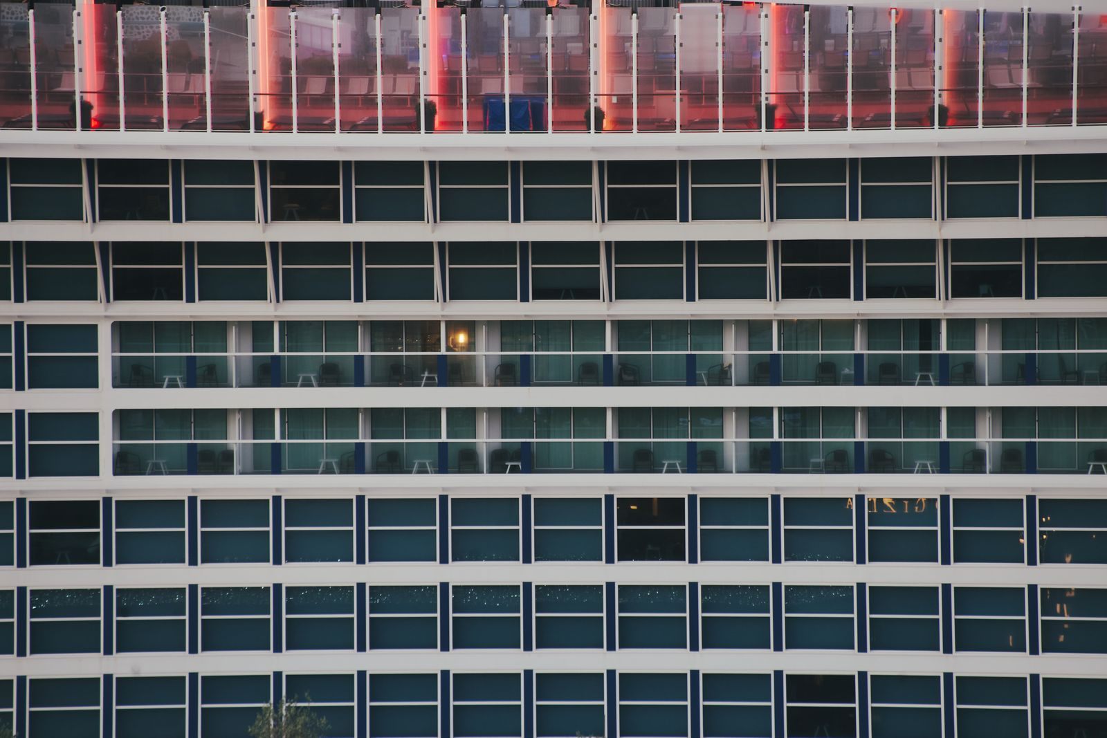 Rows of balconies and windows along the side of a large cruise ship, the cabins cruise line reviews talk about