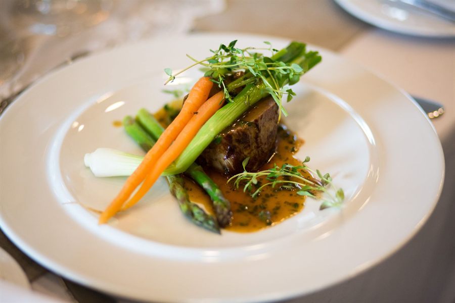 A plated main course of beef with carrots and asparagus